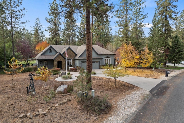 view of front facade featuring an attached garage, driveway, and stone siding