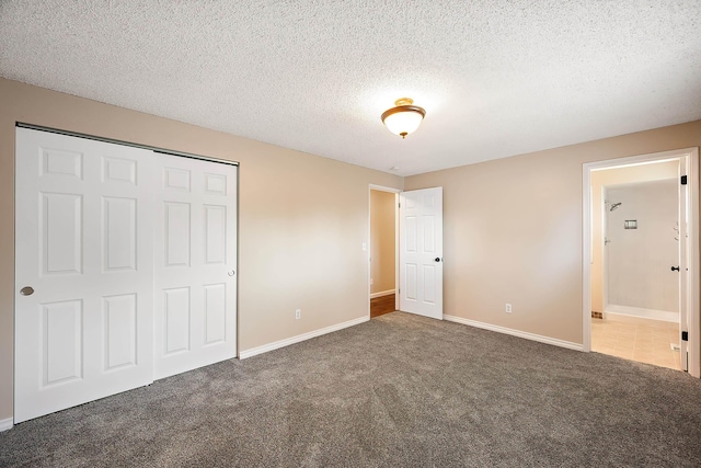 unfurnished bedroom featuring a closet, baseboards, carpet flooring, and a textured ceiling
