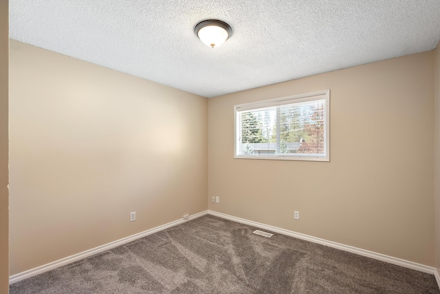 carpeted empty room featuring visible vents, a textured ceiling, and baseboards
