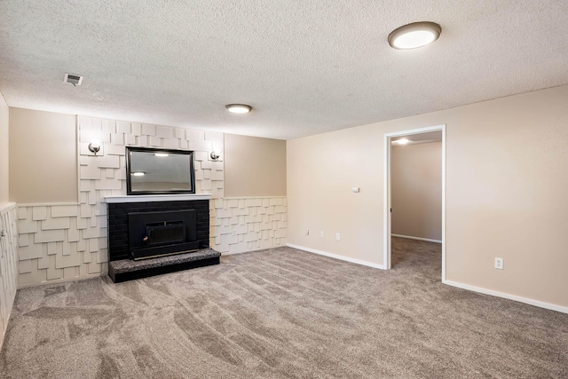unfurnished living room featuring baseboards, carpet, a brick fireplace, and a textured ceiling