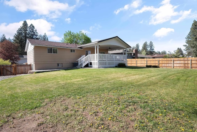 back of house featuring a fenced backyard, stairs, and a lawn