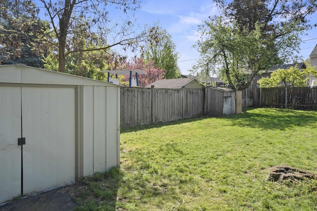 view of yard featuring an outbuilding, a shed, and a fenced backyard