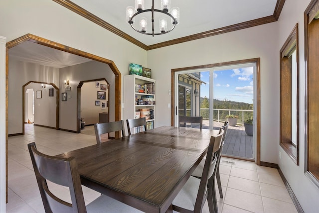 dining space with crown molding, baseboards, a notable chandelier, and light tile patterned floors
