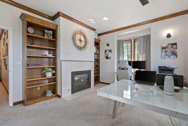 carpeted office with crown molding, baseboards, built in features, and a tile fireplace