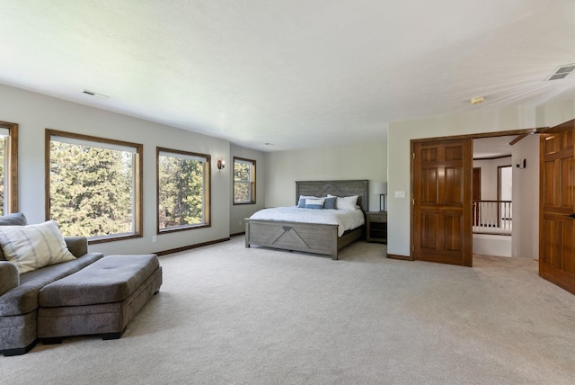bedroom featuring visible vents, multiple windows, and light carpet