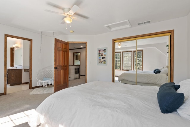 bedroom with ceiling fan, attic access, visible vents, a closet, and light carpet