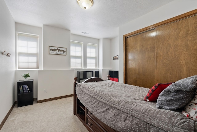 bedroom featuring baseboards, visible vents, light carpet, and multiple windows