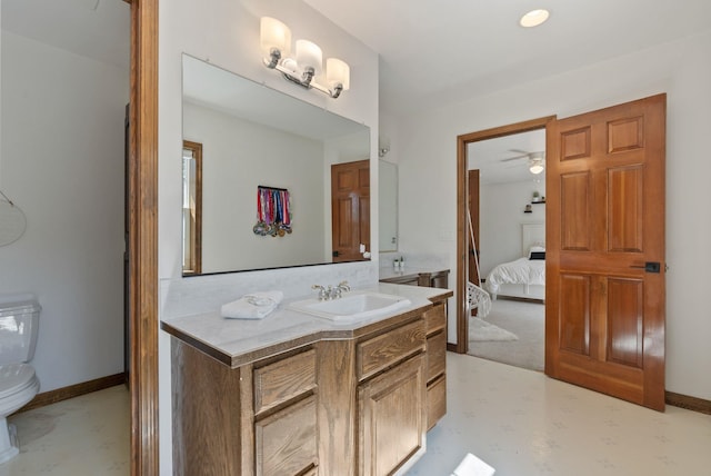 ensuite bathroom with ceiling fan, vanity, toilet, baseboards, and ensuite bathroom