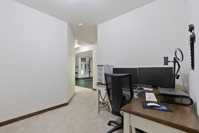 office featuring baseboards and light carpet