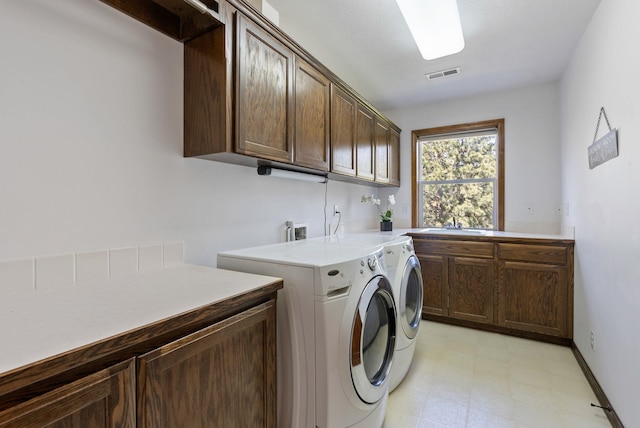 clothes washing area featuring cabinet space, independent washer and dryer, visible vents, and light floors
