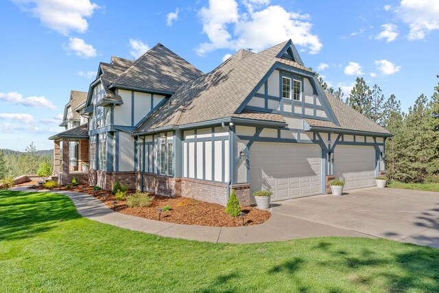 view of home's exterior featuring a shingled roof, brick siding, stucco siding, concrete driveway, and a lawn