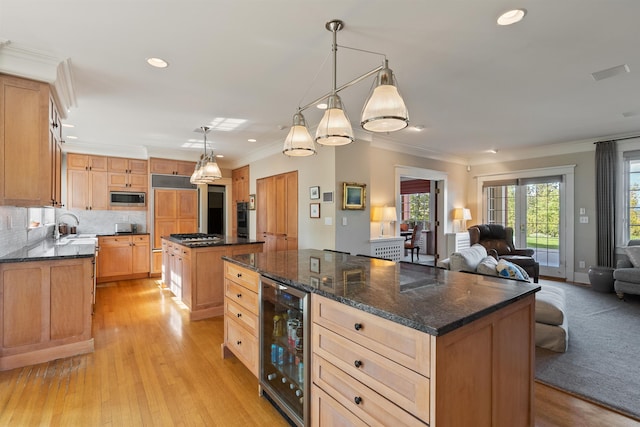 615 E 16th Ave, Spokane, WA 99203 - kitchen with a center island, stainless steel microwave, open floor plan, wine cooler, and ornamental molding