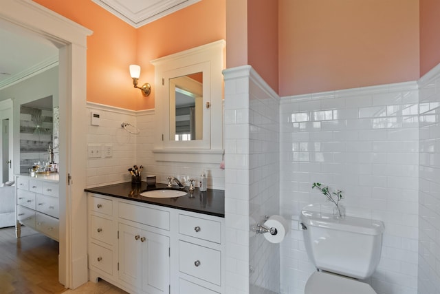 615 E 16th Ave, Spokane, WA 99203 - bathroom featuring tile walls, toilet, ornamental molding, wainscoting, and vanity