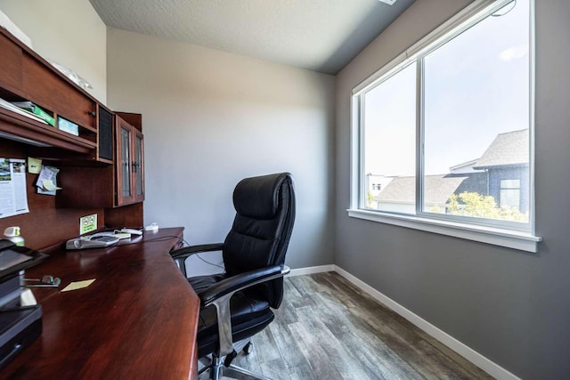 office with baseboards, a textured ceiling, and wood finished floors
