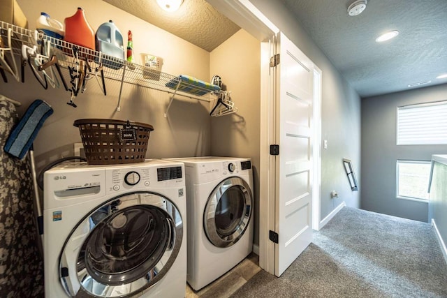 laundry area featuring laundry area, a textured ceiling, washing machine and dryer, baseboards, and carpet flooring