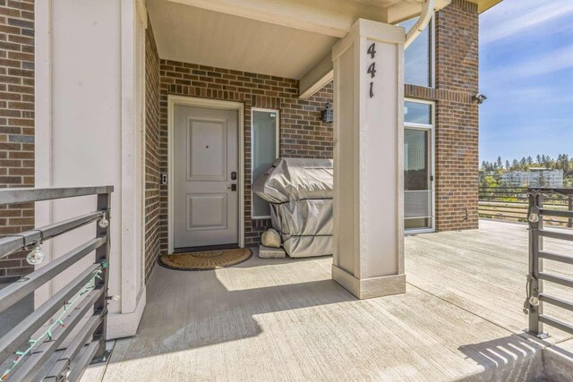 doorway to property featuring brick siding