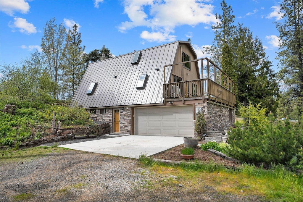16003 S Cheney Spokane Rd, Cheney, WA 99004 - view of front facade featuring a garage, a gambrel roof, driveway, and stone siding