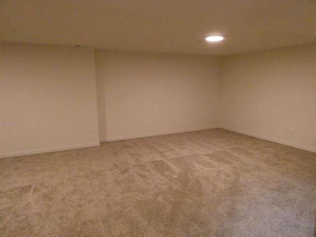 empty room featuring recessed lighting, baseboards, and light carpet
