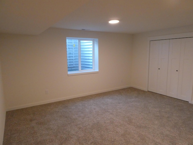 unfurnished bedroom featuring baseboards, recessed lighting, carpet, and a closet
