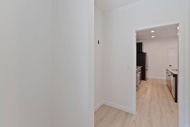hallway featuring recessed lighting, baseboards, and light wood-style floors