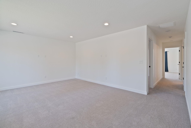 unfurnished room with baseboards, recessed lighting, and light carpet
