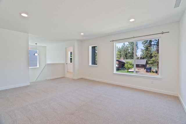 spare room featuring visible vents, recessed lighting, and light colored carpet
