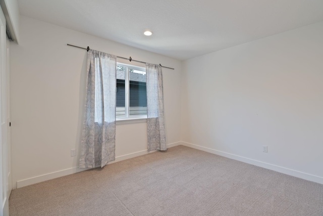 spare room with carpet floors, recessed lighting, and baseboards