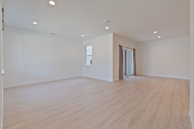 spare room featuring recessed lighting, baseboards, and light wood-style flooring