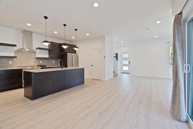 kitchen with light countertops, stainless steel appliances, open shelves, and wall chimney exhaust hood