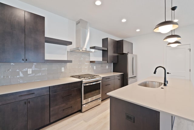 kitchen with wall chimney range hood, appliances with stainless steel finishes, open shelves, a sink, and light countertops