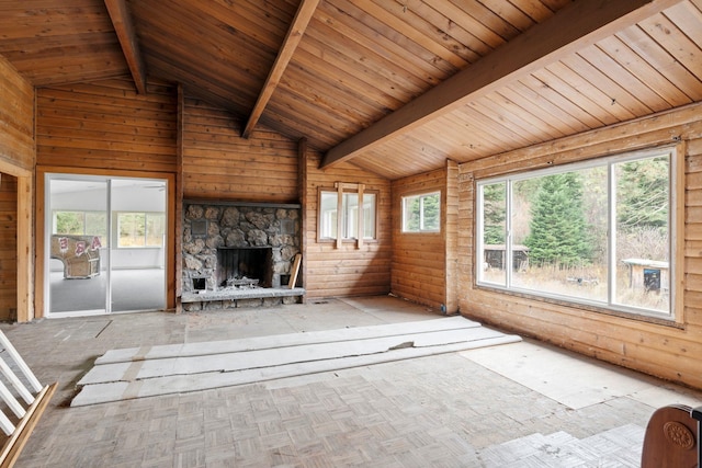 unfurnished living room featuring wooden ceiling, wood walls, a stone fireplace, and vaulted ceiling with beams