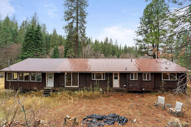 single story home featuring entry steps and metal roof