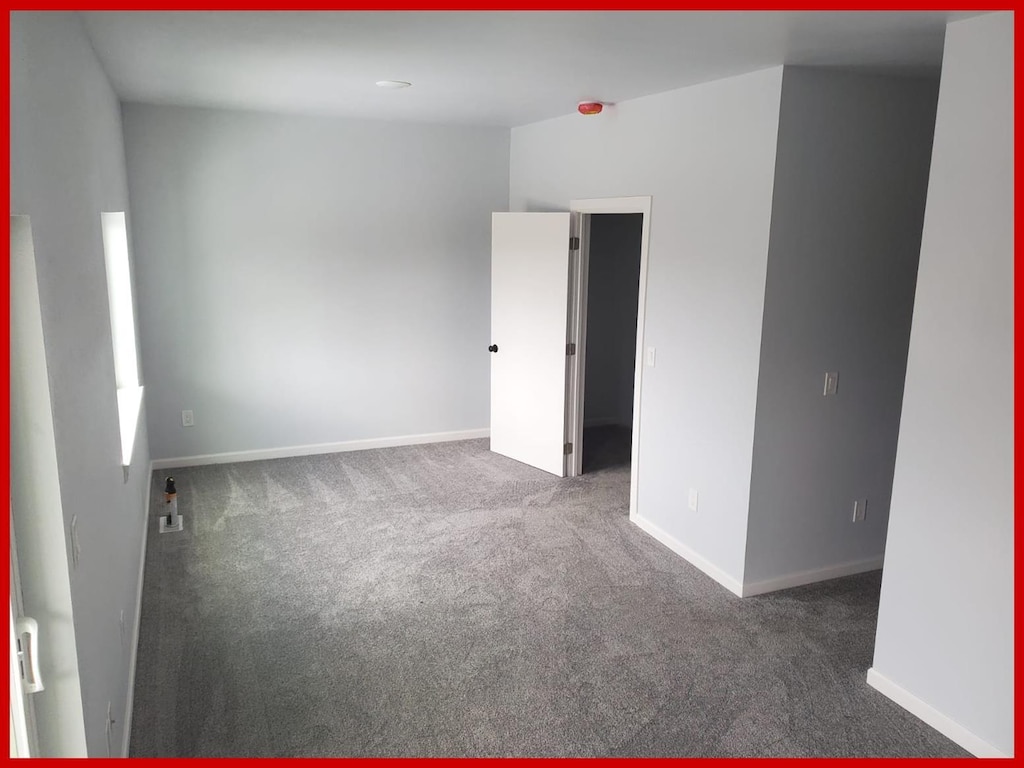 carpeted empty room with baseboards