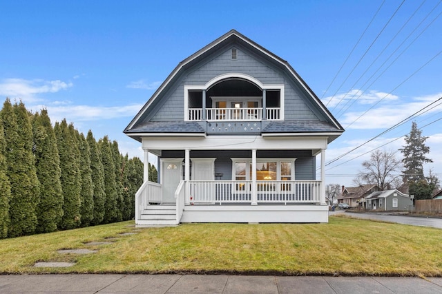 dutch colonial featuring a porch, a balcony, and a front yard