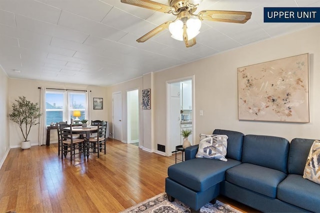 dining space featuring baseboards, ornamental molding, and light wood-type flooring