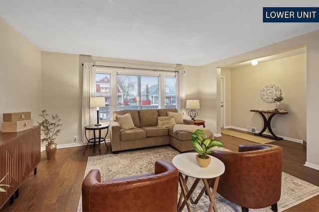 living area featuring baseboards, wood finished floors, and visible vents