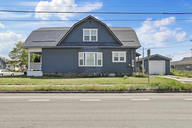 bungalow-style home with a gambrel roof, a garage, a front yard, an outbuilding, and driveway