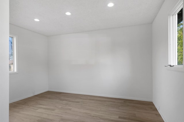 spare room featuring light wood-type flooring, recessed lighting, and a healthy amount of sunlight