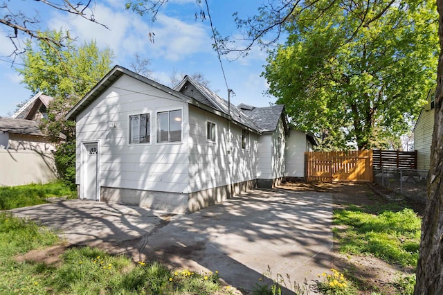 exterior space with a patio area, fence, and roof with shingles