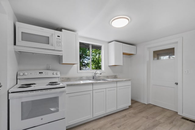 kitchen with a sink, light wood-style floors, white appliances, light countertops, and white cabinetry