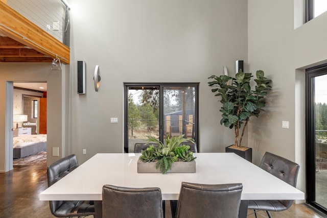 dining room with a high ceiling and beam ceiling