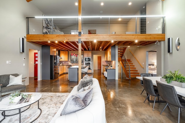 living area with concrete flooring and stairs