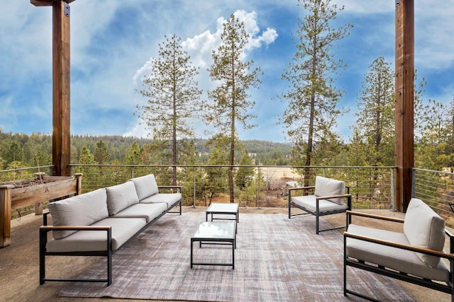 view of patio / terrace with a view of trees and an outdoor living space