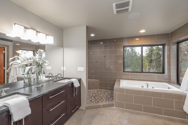 bathroom featuring double vanity, visible vents, a sink, and a garden tub