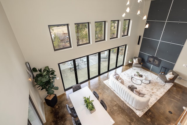 living area with concrete floors and a towering ceiling