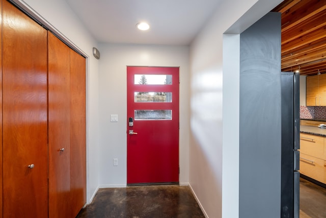 entryway featuring concrete flooring, baseboards, and recessed lighting