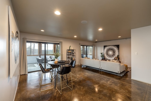 dining area with recessed lighting, finished concrete flooring, and baseboards