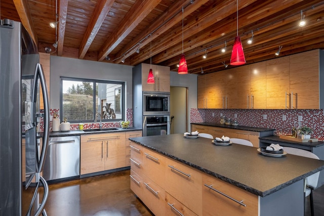 kitchen with concrete flooring, dark countertops, appliances with stainless steel finishes, a sink, and backsplash