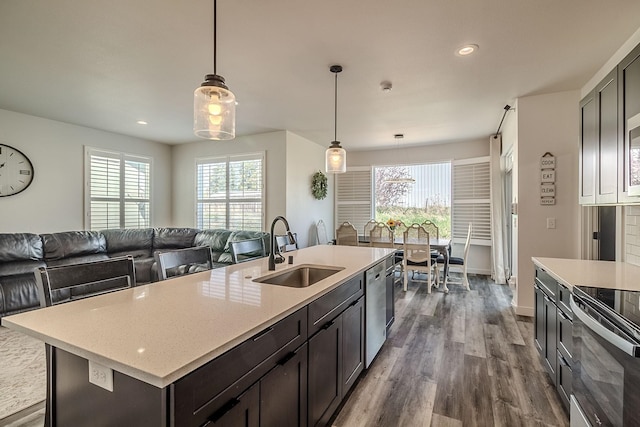 kitchen featuring a sink, appliances with stainless steel finishes, plenty of natural light, and dark wood finished floors