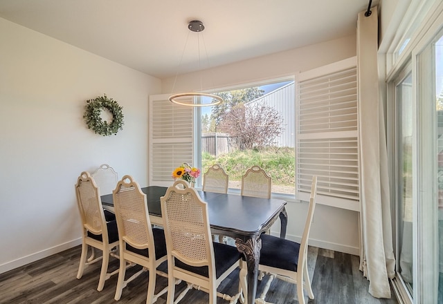 dining area featuring baseboards, a chandelier, and dark wood-type flooring